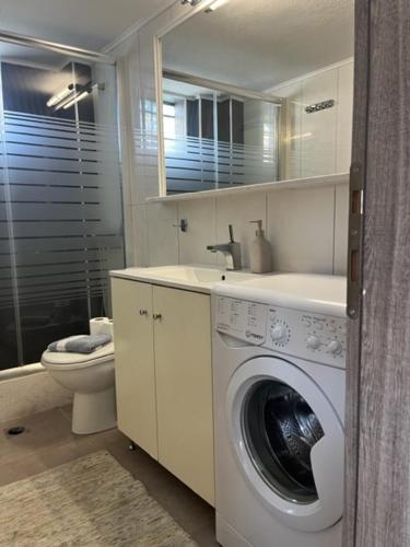 W łazience znajduje się pralka i umywalka. w obiekcie Polychrono Apartments w mieście Polychrono