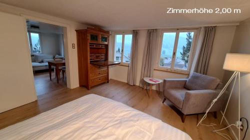 ein Schlafzimmer mit einem Bett, einem Stuhl und einem Tisch in der Unterkunft Haus an sonniger Lage, schöner Blick auf Alpstein in Urnäsch