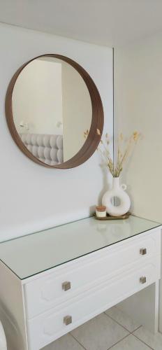 a white dresser with a mirror and a vase on it at Electra Villa & Pool Studios in Gaios