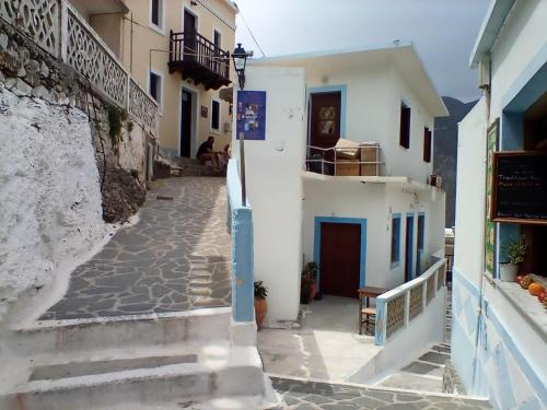 an alley in a town with white buildings at Olympos apt with amazing mountain view in Olympos