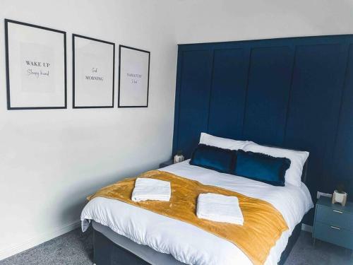 Farnworth的住宿－Comfortable Home In Bolton，蓝色和白色的卧室配有带两个枕头的床