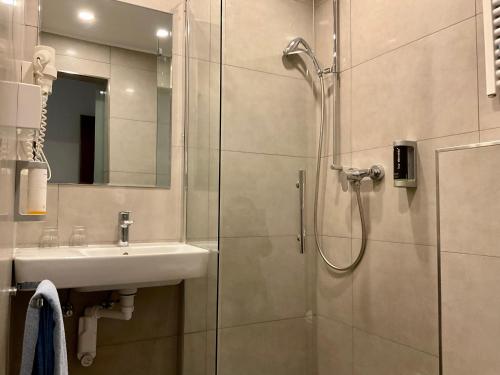 a bathroom with a sink and a shower at Hotel Royal in Villingen-Schwenningen