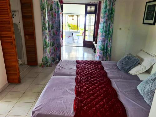 a bed with a blanket on it in a room at Maison spacieuse à Saint-Joseph avec vue sur la mer in Saint-Joseph