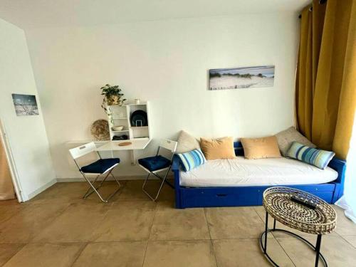 un salon avec un canapé et une table dans l'établissement Studio loggia 80m de la mer, à La Grande Motte