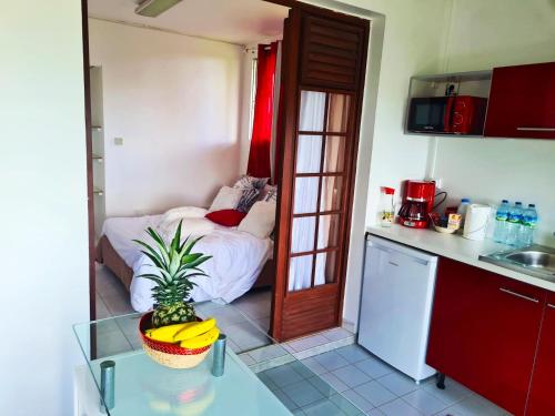 a kitchen with a bed and a table in a room at Maison spacieuse à Saint-Joseph avec vue sur la mer in Saint-Joseph