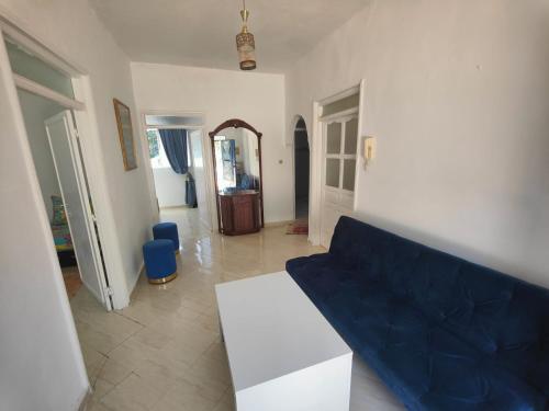 uma sala de estar com um sofá azul e uma mesa em Maison de vacances avec vue sur mer proche Tanger em Alcácer-Ceguer