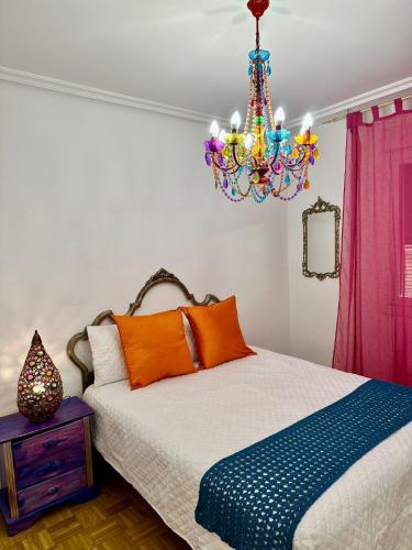 a bedroom with a bed and a chandelier at Apartamento a 10 minutos de la Calle Laurel in Logroño