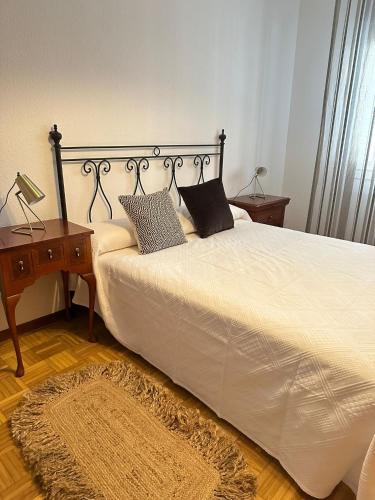 a bedroom with a bed with a nightstand and a table at Apartamento a 10 minutos de la Calle Laurel in Logroño