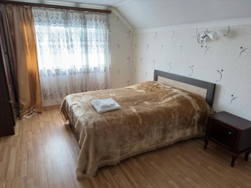 a bedroom with a large bed and a window at Chkalovka guest house with Sevan view in Sevan