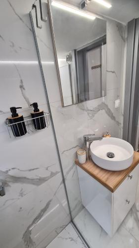 a white bathroom with a sink and a mirror at Dunant Studio in Athens