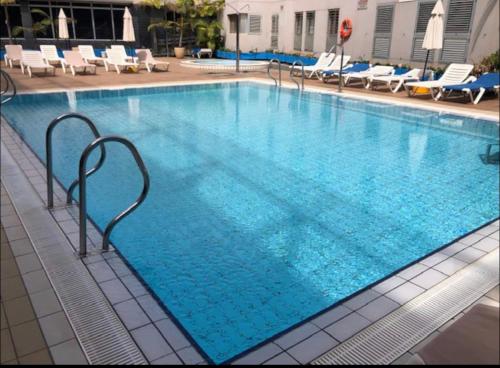 ein großer Pool mit blauem Wasser in einem Hotel in der Unterkunft Precioso apartamento en residencial con piscina cerca de la playa in Gáldar