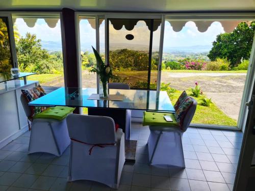 comedor con mesa, sillas y ventana en Maison de 2 chambres avec vue sur la mer jardin clos et wifi a saint joseph, en Saint-Joseph