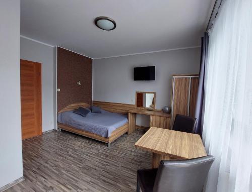 Schlafzimmer mit einem Bett, einem Schreibtisch und einem Tisch in der Unterkunft Willa Patryk in Jastrzębia Góra