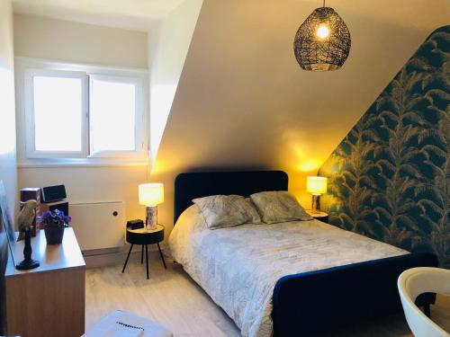 a bedroom with a bed with two lamps on it at Au pied du circuit des 24h, chez Céline in Le Mans