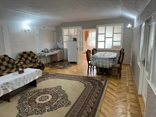 a living room with a couch and a table and a kitchen at Chkalovka guest house with Sevan view in Sevan
