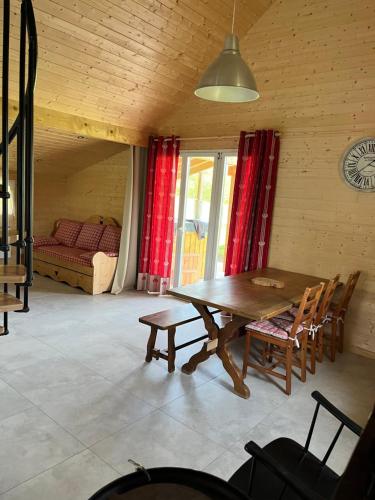 - une salle à manger avec une table, des chaises et un lit dans l'établissement La petite maison, à Champagney