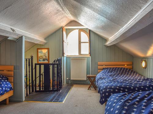 a bedroom with two beds and a window at The Moorings in Staithes