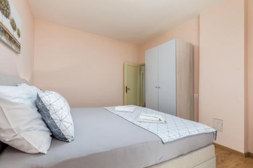 a bedroom with a large white bed and a cabinet at Apartman Darija in Vodnjan