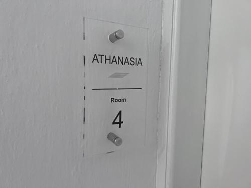 Una puerta con un cartel que dice en Atkinamineasi en ATHANASIA APARTMENTS, en Skiathos