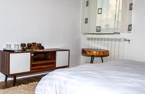 a bedroom with a bed and a dresser and a chair at N'konak Guesthouse in Pukë