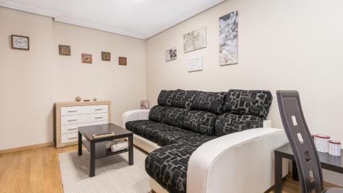 a living room with a couch and a table at Apartamento Santiago Lopez -Wifi-plaza de Garaje in Pravia