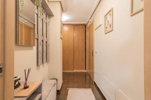 un pasillo con paredes blancas y una puerta a una habitación en Apartamento Santiago Lopez -Wifi-plaza de Garaje, en Pravia