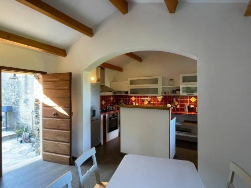 a kitchen with a white table and a white counter top at CAP CORSE - SISCO - MAISON DE CHARME 6 PERSONNES in Sisco