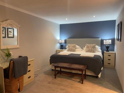a bedroom with a bed with a blue wall at Newstead Farm - Country Cottages in Curryʼs Post