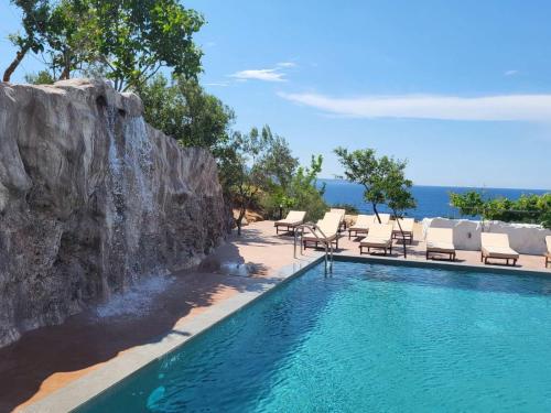 una piscina con tumbonas y una cascada en Vila Bello en Ksamil