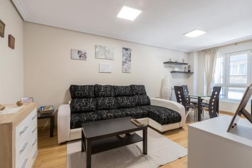 a living room with a couch and a table at Apartamento Santiago Lopez -Wifi-plaza de Garaje in Pravia