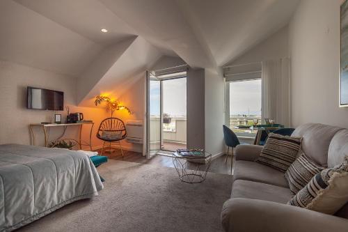 una camera da letto con un letto e un soggiorno con un divano di Urbana Homes by Home Sweet Home Aveiro ad Aveiro