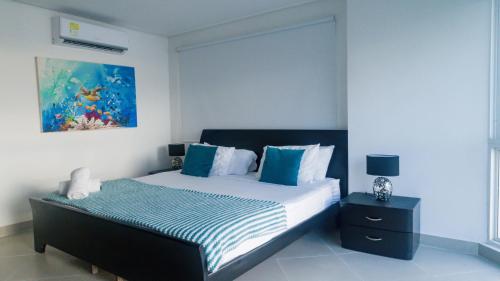a bedroom with a bed with blue and white pillows at 2B/2B Gorgeous Sunsets-Ocean View -Pool in Cartagena de Indias