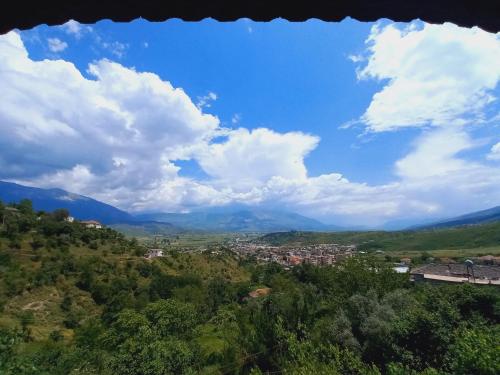 a view of a city from a hill with clouds at Sokolli Guest House in Gjirokastër