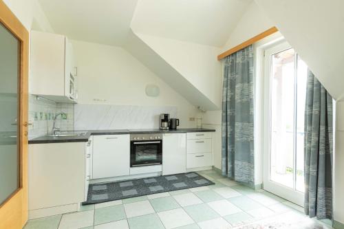a kitchen with white appliances and a large window at Appartment Isabelle - Kamille in Presseggersee
