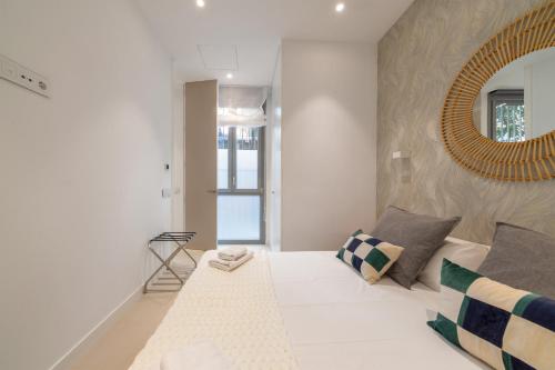 Dormitorio blanco con espejo grande en la pared en 2 bedrooms 2 bathrooms furnished - Delicias - modern- MintyStay en Madrid