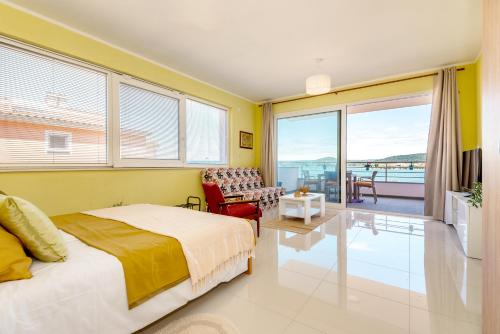 1 dormitorio con cama y vistas al océano en KAIROS, en Bilice