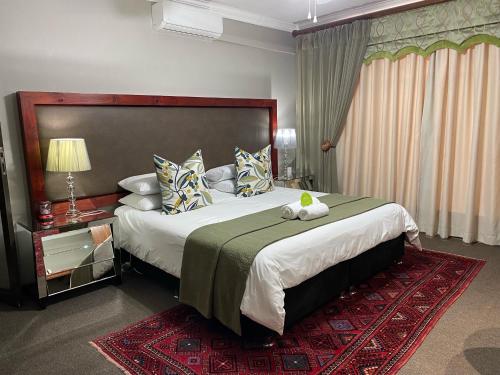 a bedroom with a large bed and a red rug at Castello Guest House, Bloemfontein in Bloemfontein