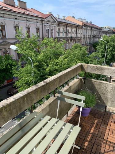 un banco sentado en la parte superior de una cornisa con edificios en Apartamenty Zasanie, en Przemyśl