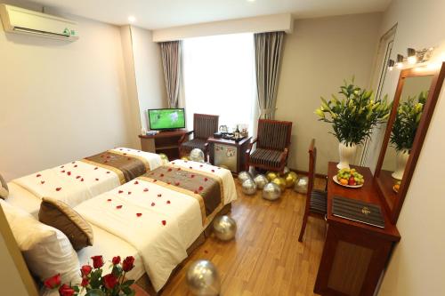 a hotel room with two beds and a television at Gallant Hotel in Hanoi