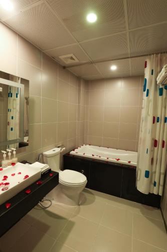 a bathroom with a toilet and a sink and a tub at Gallant Hotel in Hanoi