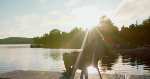 a woman sitting next to a body of water at Bonnie View Inn in Haliburton