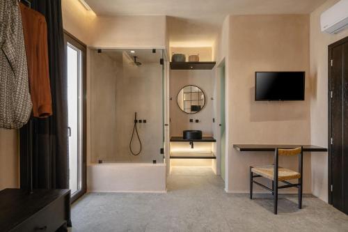 a bathroom with a shower and a television on the wall at Emery Hotel in Naxos Chora