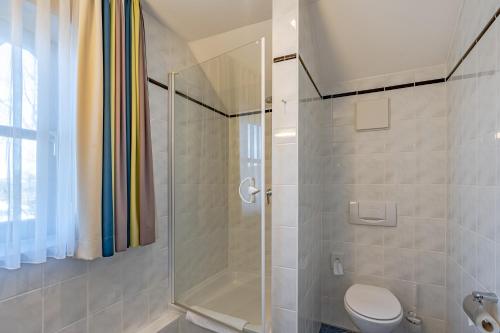 uma casa de banho com um chuveiro e um WC. em Servus Gelting em Geretsried
