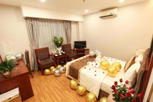 a hotel room with a bed with balloons and a desk at Gallant Hotel in Hanoi