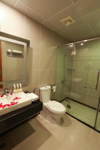 a bathroom with a toilet and a sink and a shower at Gallant Hotel in Hanoi