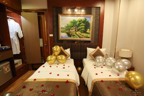 a hotel room with two beds with balloons on them at Gallant Hotel in Hanoi
