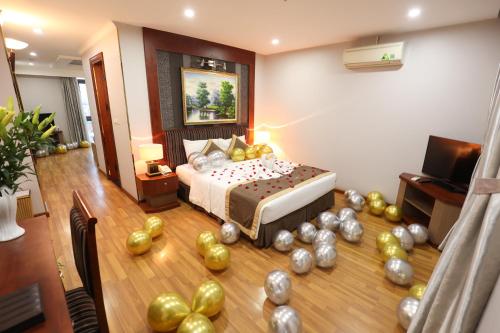 a bedroom with a bed with a bunch of gold balloons at Gallant Hotel in Hanoi