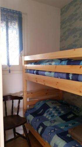 - une chambre avec 2 lits superposés et une chaise dans l'établissement T3 rez de jardin résidence Capao plage richelieu, au Cap d'Agde