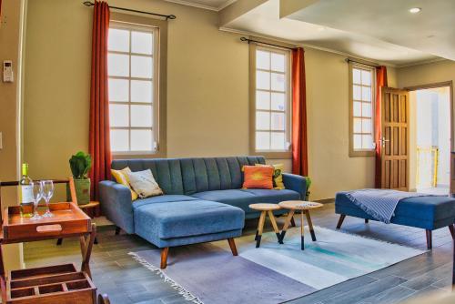 a living room with a blue couch and two chairs at City Views Spacious Mezzanine Apartments in Willemstad