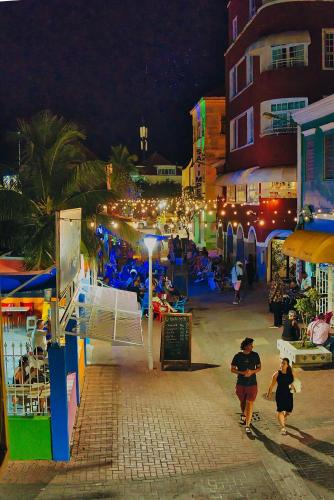 a group of people walking down a street at night at City Views Spacious Mezzanine Apartments in Willemstad